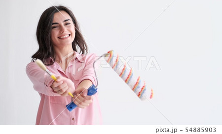 woman holding paintbrush roller 54885903