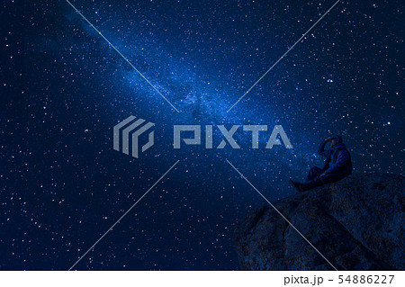 Mountaineer look at night sky with stars Mountaineer look at night sky with stars 54886227