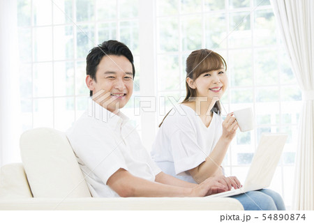 ノートパソコンで検索をする夫婦 54890874