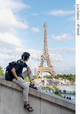 a man with backpack look at Eiffel tower in Paris a man with backpack look at Eiffel tower in Paris 54892477
