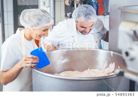 Butcher man and woman working together mincing meat 54893363
