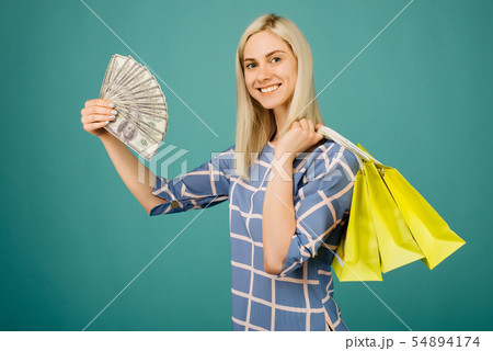 Happy girl in a checkered blouse holds one hundred 54894174