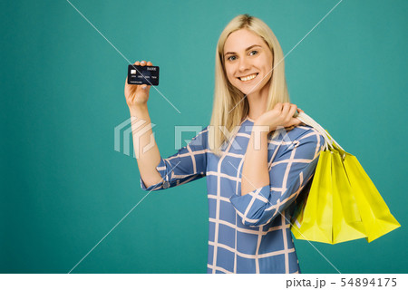 Happy girl in a checkered blouse holds credit card 54894175