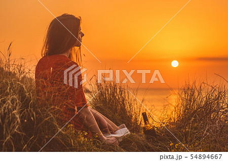 Young blonde girl in red dress sitting Young blonde girl in red dress sitting 54894667
