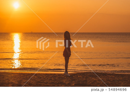 Young blonde girl in red dress jumping 54894696