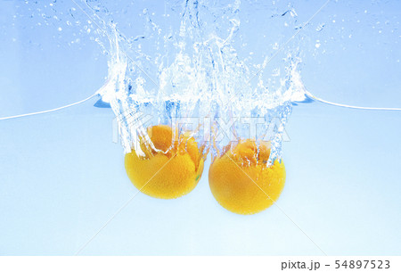 Two ripe oranges falling deeply under water with big splash Two ripe oranges falling deeply under water with big splash 54897523