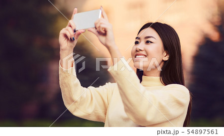 Young girl making photo of city on phone Young girl making photo of city on phone 54897561