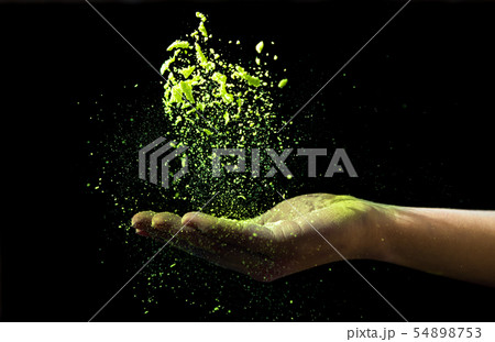Yellow holi powder dropped in woman hand on black Yellow holi powder dropped in woman hand on black 54898753