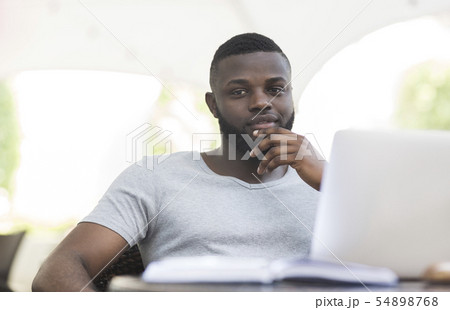 Thoughtful african american guy holding hand near chin in cafe 54898768