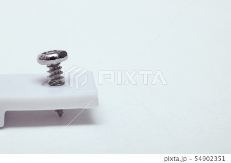 Screw twisted in white device close up 54902351