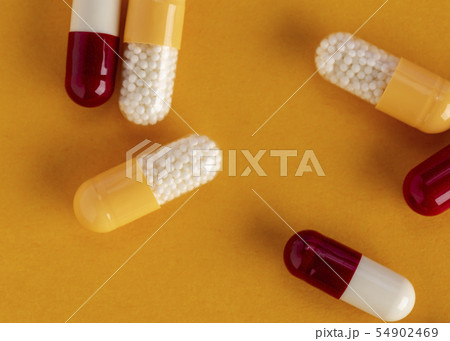 Scattered yellow and red drug capsules with active microgranules Scattered yellow and red drug capsules with active microgranules 54902469