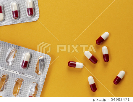Open blister pack of tablets and a few red and white medicinal capsules with atybiotics Open blister pack of tablets and a few red and white medicinal capsules with atybiotics 54902471