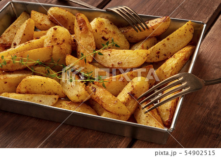 Potato wedges, oven roasted, close-up in baking tray 54902515