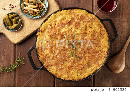 Homemade Shepherd's pie with pickles and wine on a rustic background, overhead shot Homemade Shepherd's pie with pickles and wine on a rustic background, overhead shot 54902525