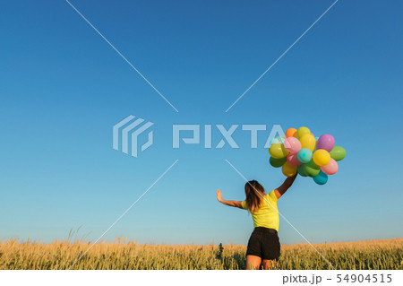 young woman with balloons on summer field young woman with balloons on summer field 54904515