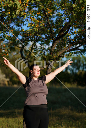 Happy woman standing in nature with open hands. 54904573