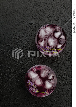 Lavender lemonade with ice on wet black background 54906385