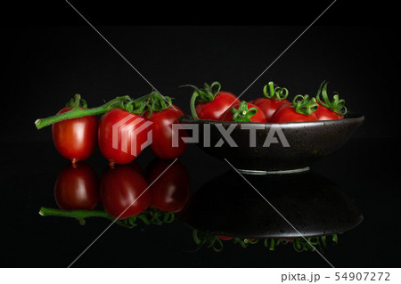 Red cherry tomato isolated on black glass Red cherry tomato isolated on black glass 54907272