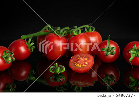 Red cherry tomato isolated on black glass Red cherry tomato isolated on black glass 54907277