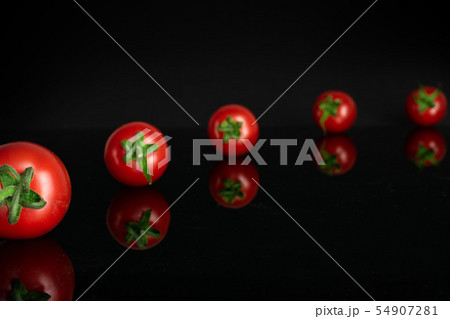 Red cherry tomato isolated on black glass Red cherry tomato isolated on black glass 54907281