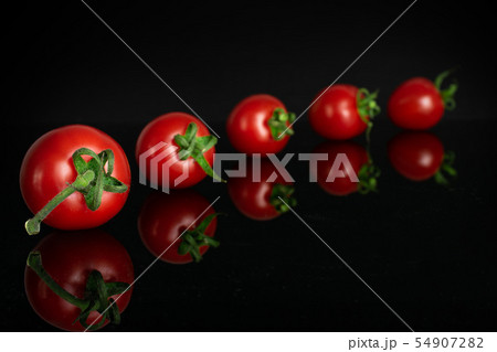 Red cherry tomato isolated on black glass 54907282
