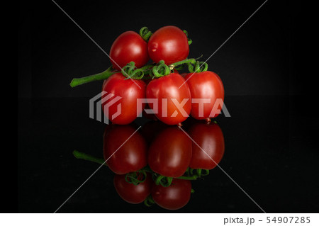 Red cherry tomato isolated on black glass 54907285