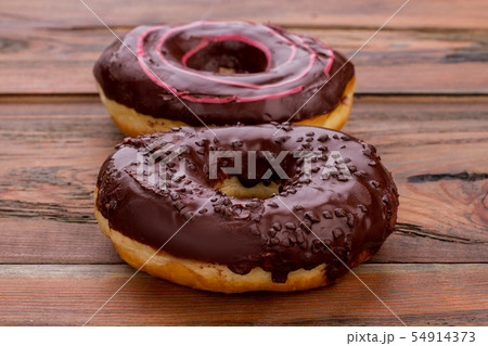 Chocolate donuts on wood table. 54914373