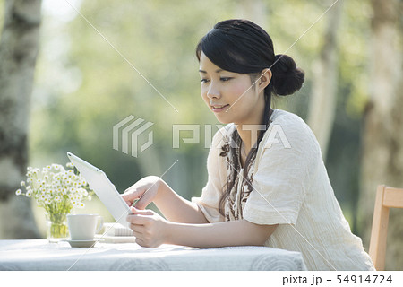 自然の中でタブレットを操作する女性 自然の中でタブレットを操作する女性 54914724