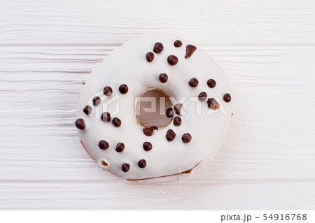 White donut with chocolate crunchies. White donut with chocolate crunchies. 54916768