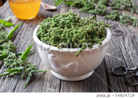 Nettle seeds in a vintage bowl with honey 54924719