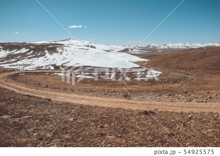 Landscape view of a winding mountain dirt road 54925575