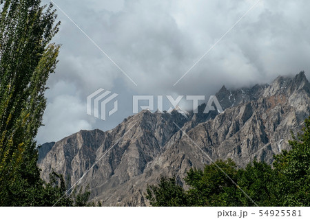 Clouds covered snow capped mountain peaks. 54925581