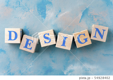 Wooden cubes with word DESIGN on blue table. Wooden cubes with word DESIGN on blue table. 54928402