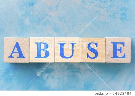 Wooden cubes with word ABUSE on blue table. Wooden cubes with word ABUSE on blue table. 54928404