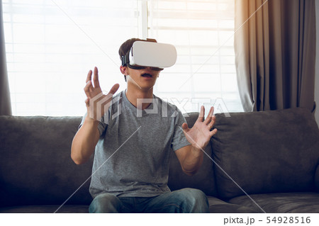 Young asian man wearing virtual reality glasses at 54928516