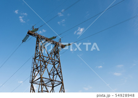 Power line tower standing against blue summer sky 54928948