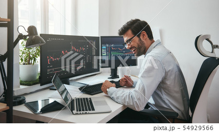 Lucky day. Happy young businessman or trader in formalwear and eyeglasses using laptop and smiling Lucky day. Happy young businessman or trader in formalwear and eyeglasses using laptop and smiling 54929566