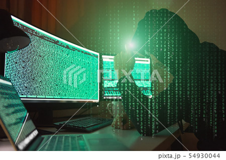 Cyber crime. Side view of young hacker in black hoodie using multiple computers and his smartphone 54930044