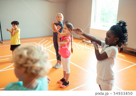 Elementary school children working out at sports lesson. 54933850
