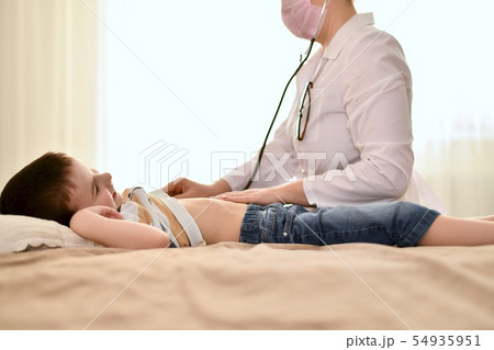 The doctor put the phonendoscope to the boy chest. 54935951