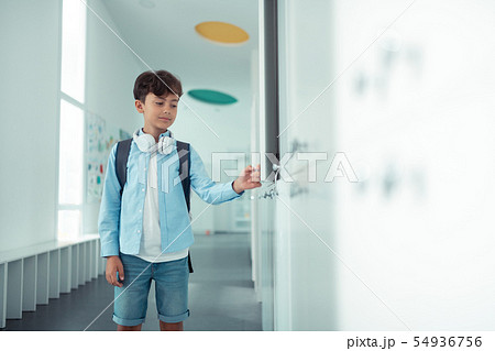 Schoolboy opening his school locker during school break Schoolboy opening his school locker during school break 54936756