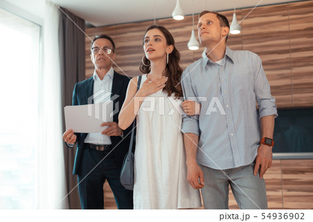 Couple standing in the room thinking about buying house Couple standing in the room thinking about buying house 54936902