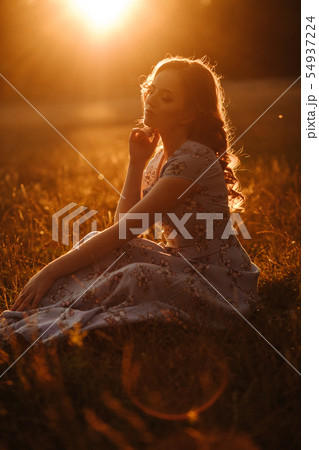 girl in a meadow park sunset orange rays girl in a meadow park sunset orange rays 54937224