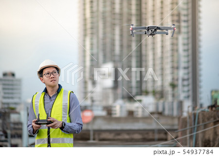 Asian engineer flying drone over construction site 54937784