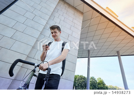 Handsome hipster man posing with bicycle in the city. 54938273