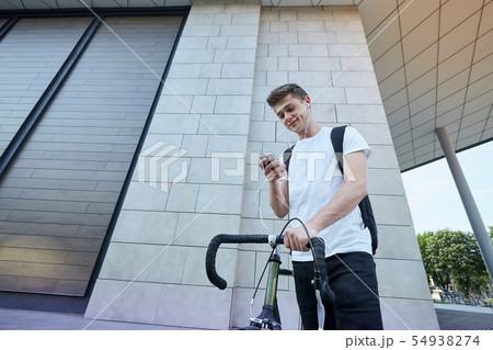 Handsome hipster man posing with bicycle in the city. 54938274