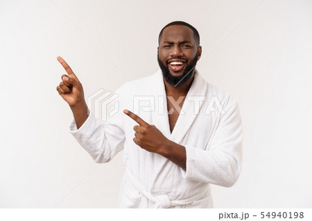 Black guy wearing a bathrobe pointing finger with surprise and happy emotion. Isolated over whtie Black guy wearing a bathrobe pointing finger with surprise and happy emotion. Isolated over whtie 54940198