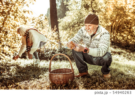 Happy man finding a big mushroom in the forest. Happy man finding a big mushroom in the forest. 54940263