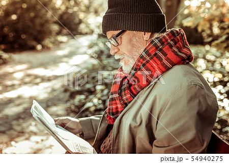 Handsome aged man reading a newspaper in the park. 54940275