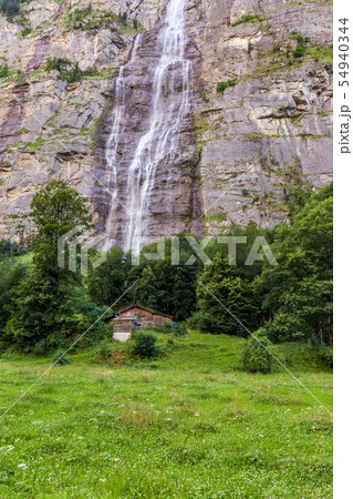 Waterfall and small house in Jungfrau valley  54940344